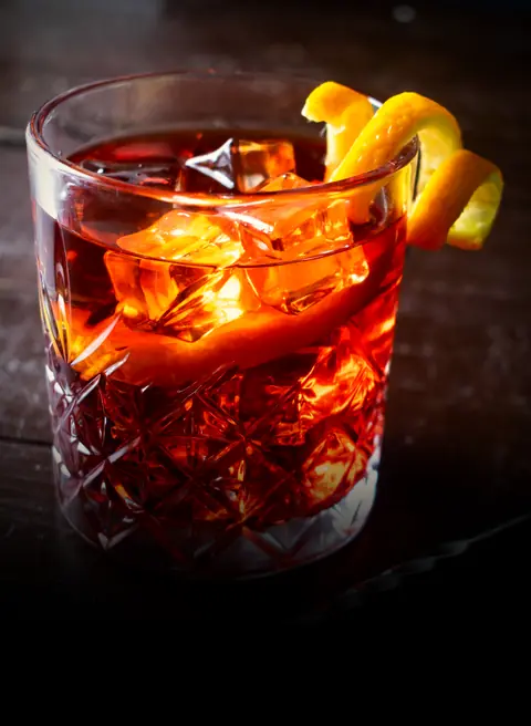 A Negroni over ice in a cut-glass tumbler with an orange peel